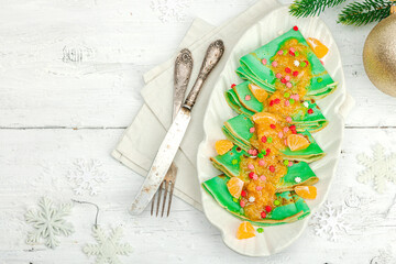 Christmas pancakes with mandarin sauce and sweet sprinkles. Festive New Year dessert, ready to eat