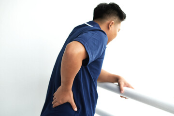 Tired young asian business man suffering neck and hand pain while working for so long at home, exhausted man rubbing and massaging his painful area and frowning, suffering osteoporosis or arthritis