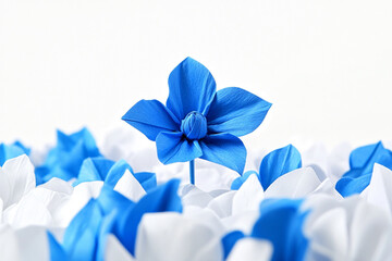 A blue flower is the only one in a field of white and blue paper