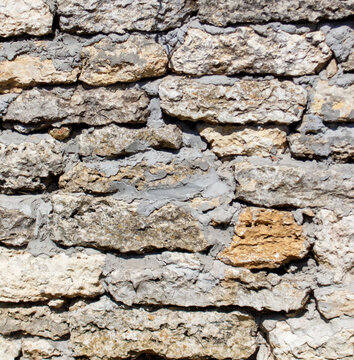 Fototapeta A wall made of large, rough, grey bricks