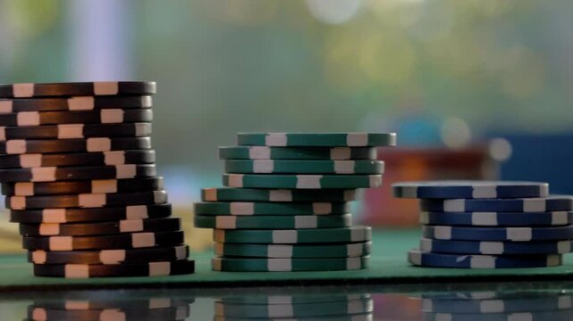 slow panning shot of stacks of poker chips sitting ontop of a poker table