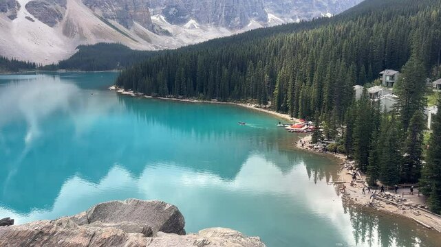 Tourists visiting and sailing on blue-green waters of Moraine Lake, Canada. Handheld