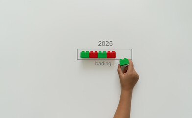 Loading new year 2024 to 2025 with child hand putting plastic block in progress bar. 