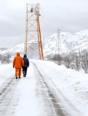 Two figures walk down a snowy path, surrounded by winter scenery and power lines reaching up toward a cloudy sky.