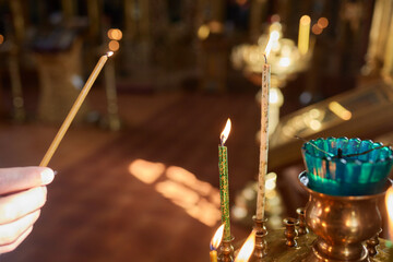 An Ornate Gold Cross Encircled by Colorful Candles Within a Beautiful Church Interior
