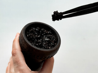 Preparing hookah bowl, filling with fresh tobacco for relaxing smoking experience