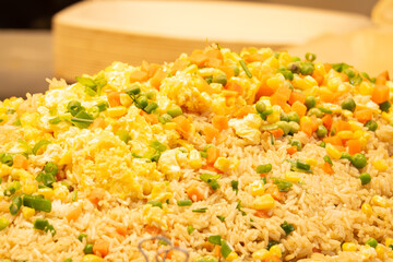A large pile of rice with vegetables on top. The rice is yellow and the vegetables are orange