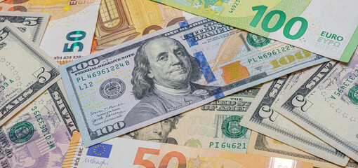 A pile of different colored bills including a $100 bill. Concept of wealth and abundance. Financial background.