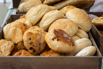 Close up of a crate with freshly baked raisin scones and sesame buns