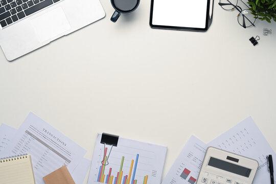 Top view digital tablet with empty display, laptop and financial document on white table