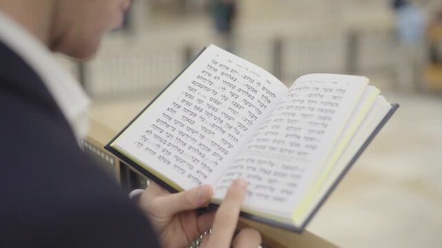 Orthodox Jew Praying With Tehillīm (Book of Psalms) At Western Wall In Jerusalem, Israel. closeup shot