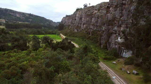 Aerial view of a path through dense vegetation next to a rocky wall at Las Rocas de Suesca