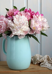 bouquet of peonies in a blue jug in the cottage, floral arrangement. garden flowers.