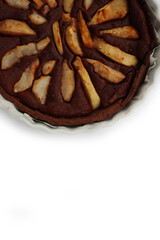 Top view of homemade Chocolate tart with sweet pear fruits in a bake pan isolated on white background