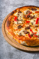 Pizza with paprika and roast beef on cutting board on stone table