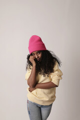 Lovely teenage girl with dark skin long afro hair poses against white background dressed in casual clothes. 