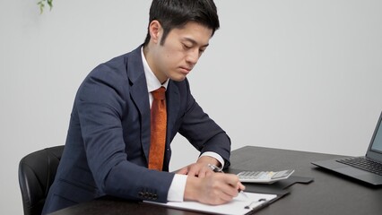 電卓で見積もりを計算するビジネスマン