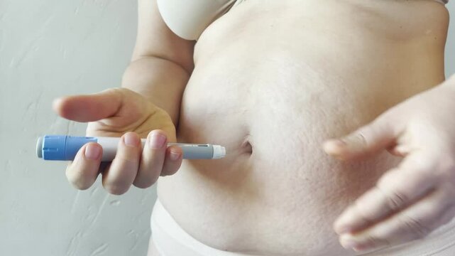 Woman making Semaglutide Injection closeup. Semaglutide or insulin Injection pen in female belly. Semaglutide Diabetes Drug Being Used For Weight Loss.