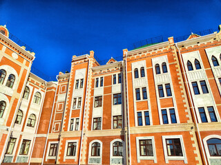 Brightly colored historic building exterior under a clear blue sky in an urban setting during...