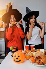 Fototapeta premium friendship, holiday and people concept - group of happy smiling friends in halloween costumes of vampire, devil, witch and cheetah at home party