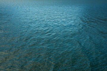Water texture. Glare and reflective surface water on the lake. Water surface abstract background of a lake or sea water pattern with small waves. Water texture