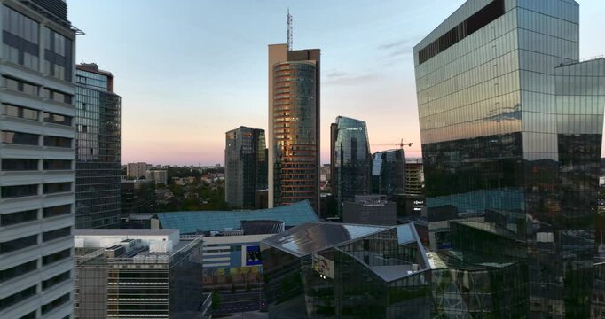Aerial evening sideways flying shot of new urban area with tall shiny glass buildings in Vilnius, Lithuania.
Constitution prospectus with city traffic are visible. High quality 4k prores footage.