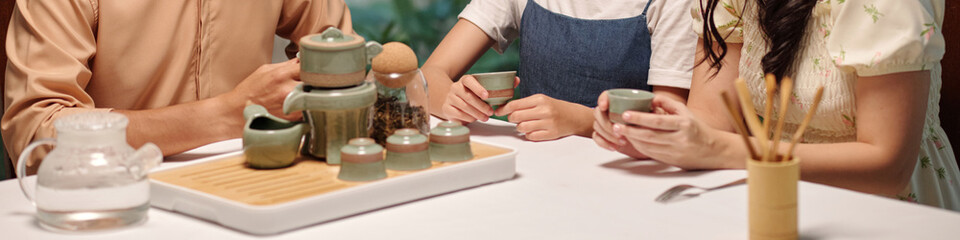 Header with family drinking tea at the table