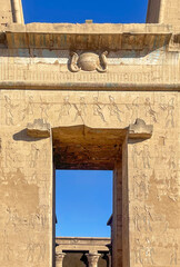 Marvel at the grand entrance to the Temple of Horus at Edfu, adorned with intricate carvings and towering columns that create a truly majestic Egyptian spectacle.