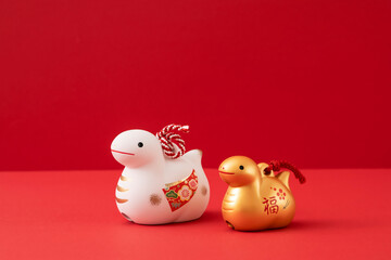 Japanese new year material. Zodiac Snake. Snakes ornament on the red background. 日本のお正月素材。干支の巳（ヘビ）。赤背景上の巳の置物