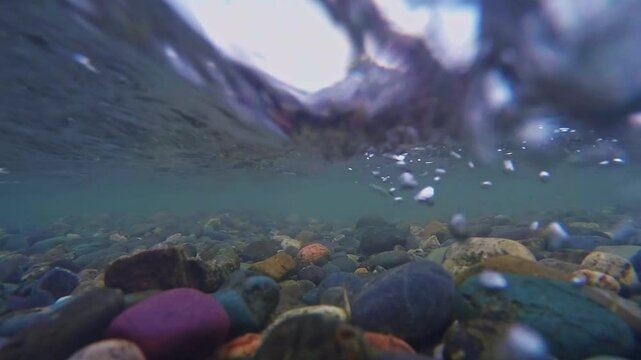The rocky bottom of a mountain river with a fast current and clear water.