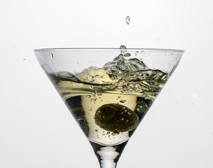 splash in a glass of dry martini with green olive, alcohol, cocktail, bar