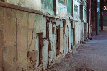Almost completely destroyed tiles on the facade of a building in the city