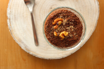 Two bowls of chia seed, chocolate and orange pudding. Healthy snack, wooden background. Top view.