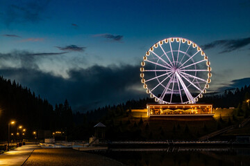 Night landscape, Ferris wheel with beautiful illumination at night. Attraction in Bukovel.