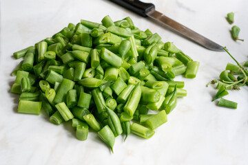 Chopped fresh french beans for cooking on marble worktop.