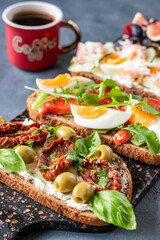 Open sandwiches with avocado and salmon, sun-dried tomatoes and olives, crabs with egg, figs with berries. For breakfast with coffee.