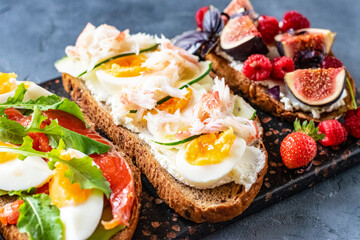 Open sandwiches with avocado and salmon, crabs with egg, figs with berries.