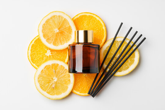 Aromatic display of essential oils with citrus fruit and chopsticks on a minimalist background