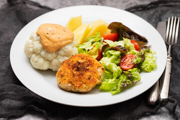 Fried chicken meatballs with boiled vegetables on white plate