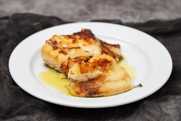 fried cod fish with olive oil on white dish