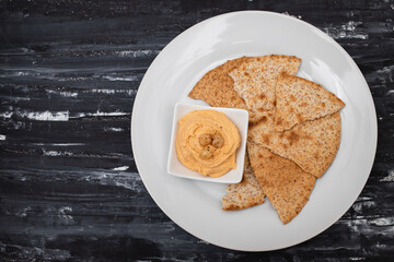 Classic chickpea hummus with, olive oil and toasts on plate