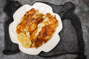 fried breaded fish fillets on white beautiful plate