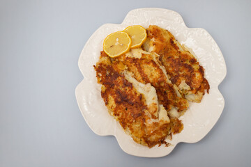 fried breaded fish fillets on white beautiful plate