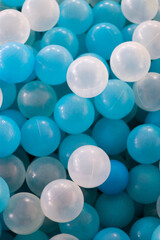 Close up of plastic white and blue balls in dry pool on the playground