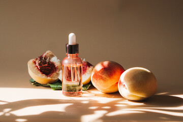 Natural cosmetics, hair and skin care. Organic oil. Bottle with essential oil, fresh peaches on background. High quality photo