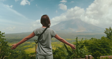 Young woman is embracing the breathtaking beauty of a tropical landscape, with the majestic mayon volcano standing tall in the distance