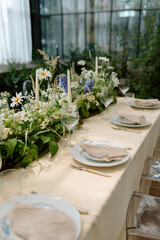 Modern stylish wedding table setting. The wedding decor. The pastel colors flowers bouquet. Natural beautiful wedding decorations. Minimalistic wedding decorations