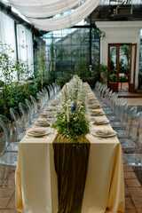 Modern stylish wedding table setting. The wedding decor. The pastel colors flowers bouquet. Natural beautiful wedding decorations. Minimalistic wedding decorations