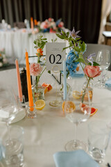 Modern stylish wedding table setting. Italian summer style. The wedding decor. The pastel colors flowers bouquet. Natural beautiful wedding decorations. Minimalistic wedding decorations