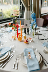 Modern stylish wedding table setting. Italian summer style. The wedding decor. The pastel colors flowers bouquet. Natural beautiful wedding decorations. Minimalistic wedding decorations